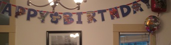 Happy Birthday banner hanging on wall in dining room
