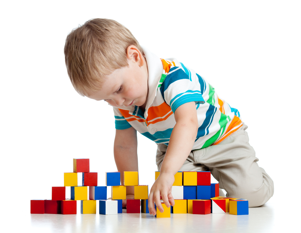 Preschool boy playing with colorful blocks
