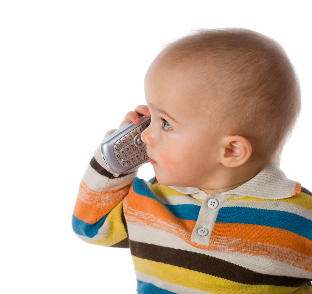 Toddler boy holding cell phone by his ear
